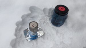 Cooking system and bear canister in the snow for winter camping.