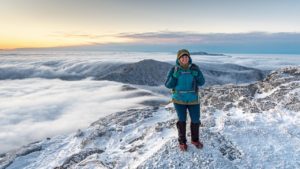 Stephanie stands on Camel's Hump with thick cloud layer below
