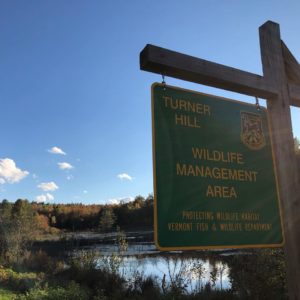 Turner Hill Wildlife Management Area sign overlooking pond.