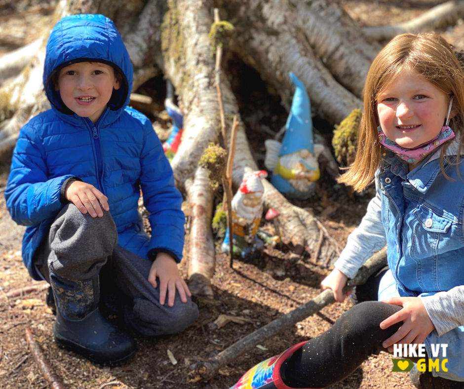Boy and girl with ceramic gnomes on Gnome Trail, a kid-friendly hike.