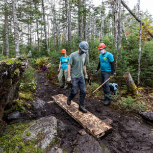 Trail crew tests out puncheon they built to cross muddy terrain.