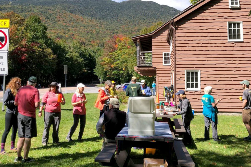 Barnes Camp volunteers assist hikers on a sunny day.