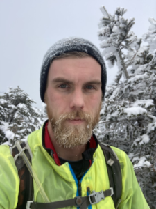 Nigel Bates faces camera on a snowy outdoor day