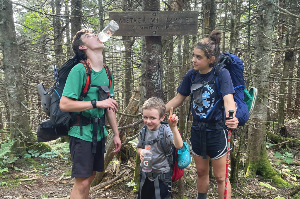 Krebs kids -- Charlie, Joe, and Ruth -- at a trail sign for Haystack Mt.