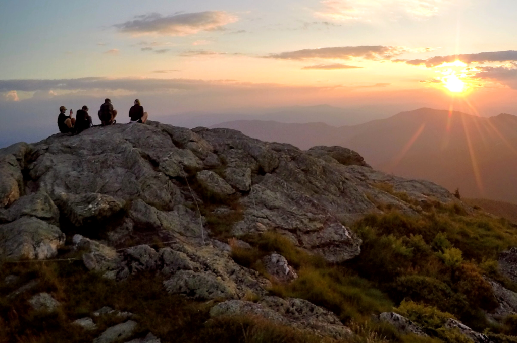 Hikers silhouetted on Mansfield summit as sun rises 