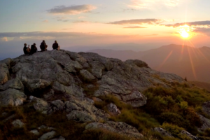 Hikers silhouetted on Mansfield summit as sun rises