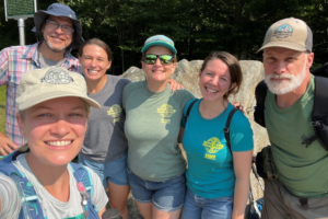 Liz Derstine (left) smiles with hikers and GMC staff before leading a hike up Mt. Mansfield.