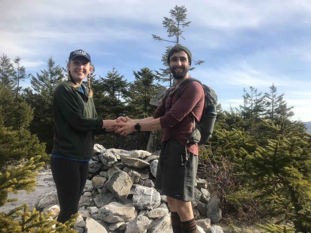 Owen Rachampbell (right) and wife Anna embrace at the top of a mountain