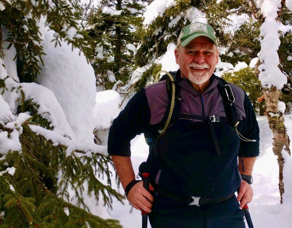 Terry Lovelette poses with hiking poles on a snowy hike