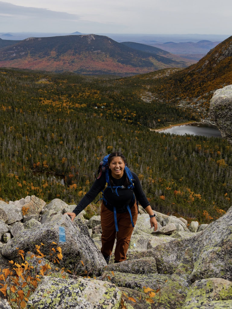 A photo of Lily LaRegina smiling as she hikes