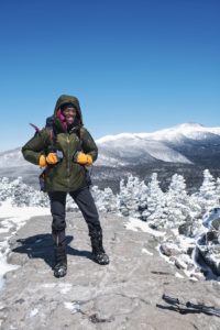 Mardi Fuller smiles at the top of Mt. Jackson while winter hiking in the White Mountains of New Hampshire