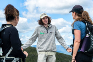Liam Ebner, Summit Steward for the Adirondack Club, talks with hikers on an alpine summit.