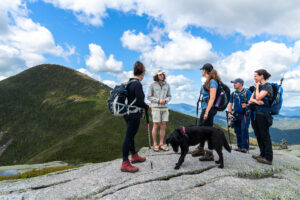 Liam Ebner, Summit Steward for the Adirondack Club, talks with hikers on an alpine summit.