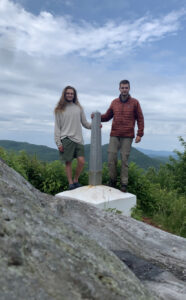two friends stand on the journey's end monument