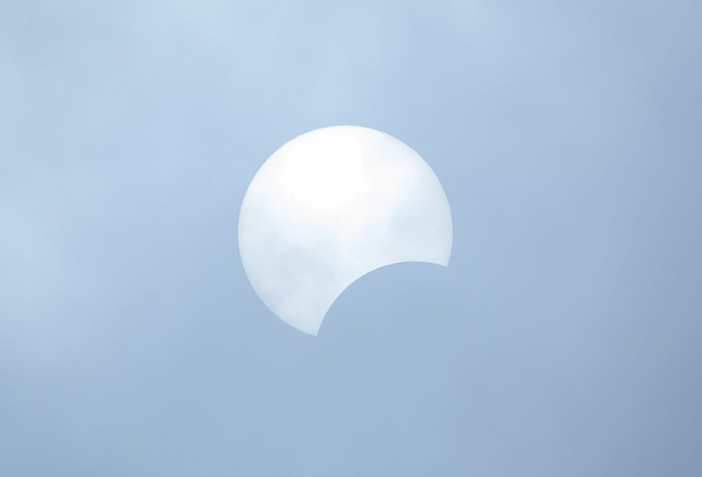 The moon partially blocks the sun during a partial solar eclipse.