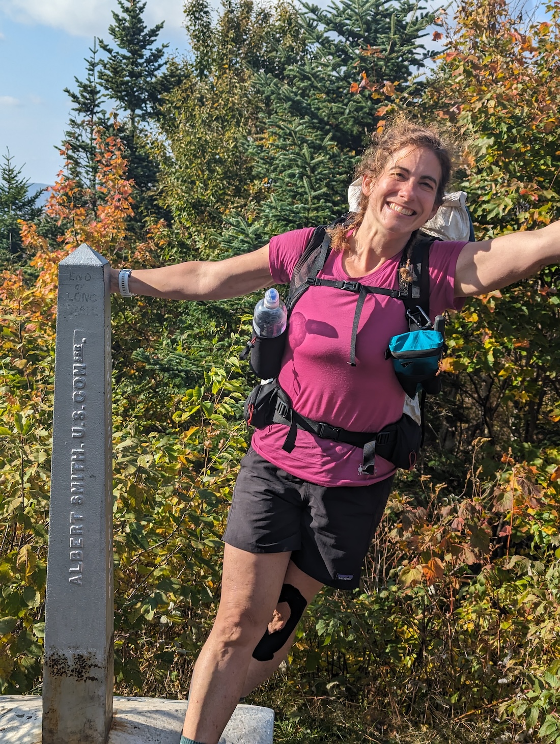 woman in pink shirt leans off Journey's End monument