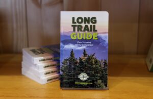 the Long Trail Guide book (purple cover, green lettering) is on display with a small stack of books behind it.